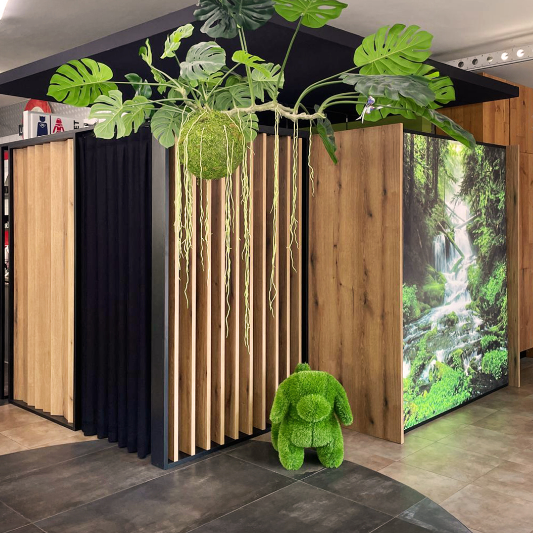 Immagine tricoroom decorata con erba finta ed elementi naturali decorativi verdi. Dettagli in legno 